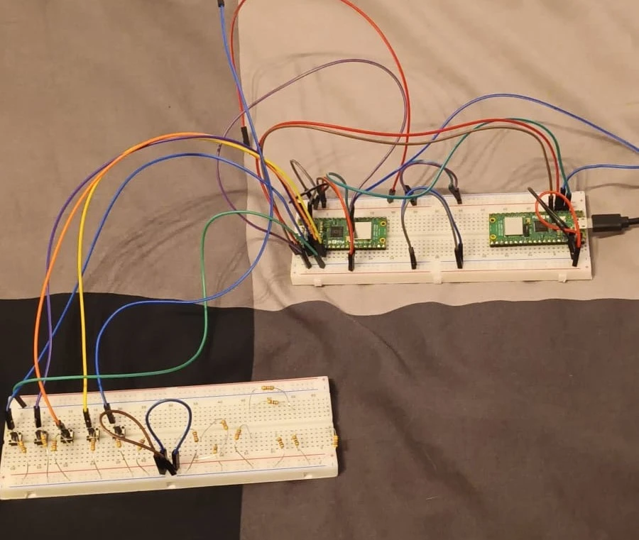 Main breadboard with picos (top), currently 1/2 breadboards for the buttons to control the piano keys (bottom)